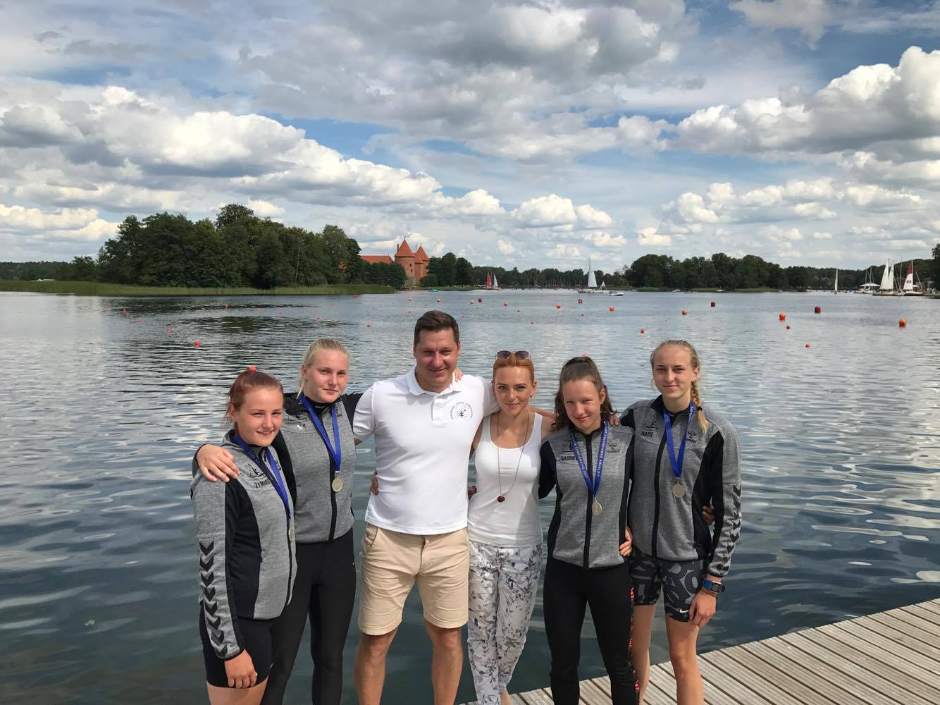 Panevėžio sporto gimnazijos auklėtinės tapo šalies čempionėmis keturviečių baidarių 500 m rungtyje, šalia – treneriai Vytautas ir Dalia Vaičikoniai.